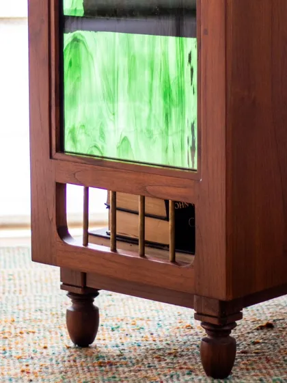 The Aamira storage unit is a piece with details galore. It can function as a bookcase, crockery unit, or bar, and features finger grooves, stained glass, and brass inserts, making it a statement piece for any living or dining area.