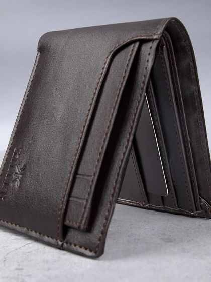 A standing shot of the dark brown wallet, showing its profile.