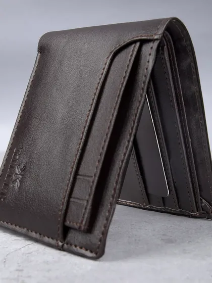 A standing shot of the dark brown wallet, showing its profile.