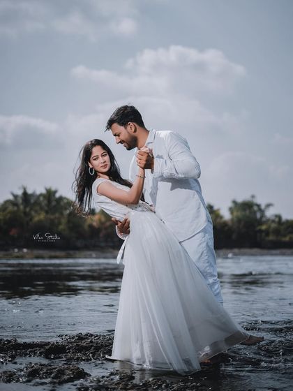 A classic dance pose in the water, full of elegance and romance. This shot combines beautiful scenery with a timeless expression of love.