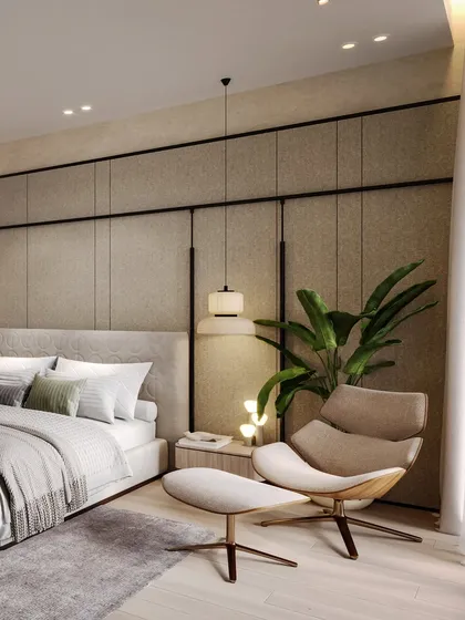 A cozy reading corner is created with a stylish lounge chair and ottoman, perfect for enjoying the villa's serene surroundings.