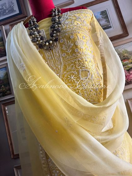 A draped view of the yellow suit, highlighting the ombré dyed dupatta and the texture of the embroidery.