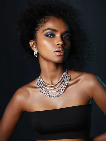 A wider shot of the electric blue eye look, showcasing the dramatic hair and beautiful jewelry that complete this high-end portfolio image.