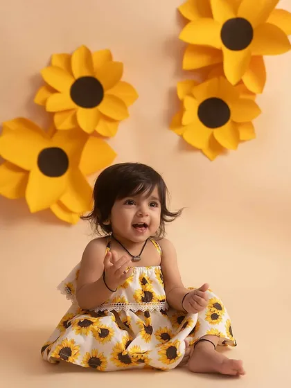 A happy, open-mouthed smile from this adorable girl in her sunflower dress.