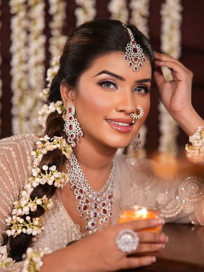 A happy and glowing look for a festive occasion. The hair is styled in a beautiful braid with fresh flowers, and the makeup is kept luminous and bright.
