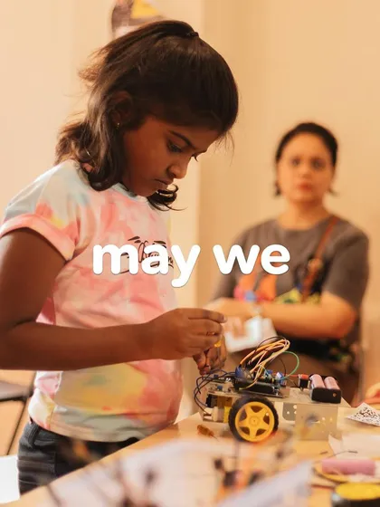 A close-up of a girl working on her robot, a testament to the focus and skill we build in our STEM programs.