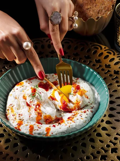 A close up shot of Turkish eggs (Cilbir) from the Club Jolies menu. I focused on the moment the yolk is broken, capturing the rich, runny texture against the creamy yogurt and chili oil.