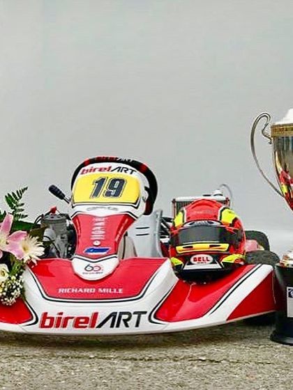 The spoils of victory. The Birel ART kart, helmet, and the FIA World Championship trophy, representing our global success.