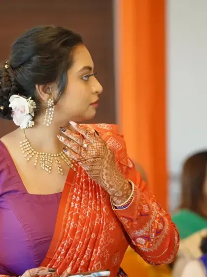 A candid moment from a traditional ceremony. The makeup is soft and elegant, with a beautiful floral bun, ensuring she looks her best while participating in the rituals.
