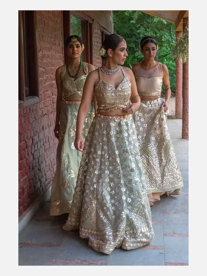 A group shot of three models walking in a line, each wearing an elegant, intricately detailed lehenga from a designer collection. This image demonstrates my capability in shooting cohesive campaign stories for fashion brands.