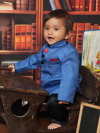 A charming portrait of the little boy at his desk. His direct look at the camera and sweet expression make this a heartwarming and memorable photo.