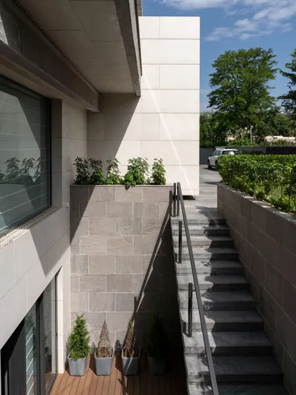 A sunken staircase provides access to the basement from the lawn, a versatile feature that makes the outdoor spaces exceptionally convenient for hosting gatherings.