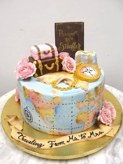 A cake for the journey from Ms. to Mrs. This travel-themed bridal shower cake features a hand-painted world map, vintage luggage, and a passport topper, telling a beautiful story of love and adventure.