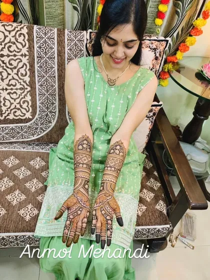 A happy bride is my greatest reward. Here is a client joyfully showing off her full bridal mehendi, with detailed patterns covering her hands and arms.