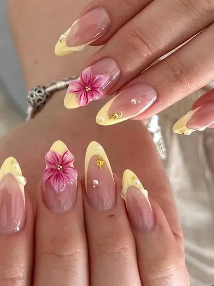 A beautiful and unique wedding nail design. We used a soft yellow French tip as the base and added vibrant, hand-sculpted 3D pink flowers with tiny gold and pearl accents.