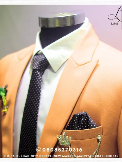 The right accessories complete the story. This is a close-up of a custom suit jacket, styled with a polka dot pocket square and distinctive lapel pins. I help you select these finishing touches to ensure your entire look is cohesive and personal.