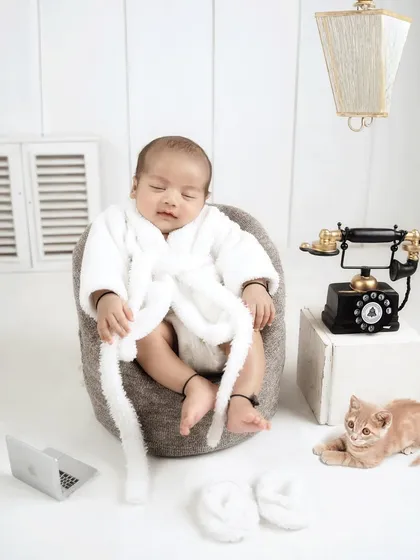This boss baby even has a furry friend! A tiny kitten joins the scene, adding an extra layer of cuteness to this creative newborn setup.