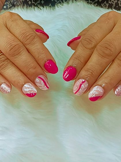 Wide nails, big vibes. This fun and vibrant set features a mix of bright pink, glitter, and accent nails with a white feather-like design.