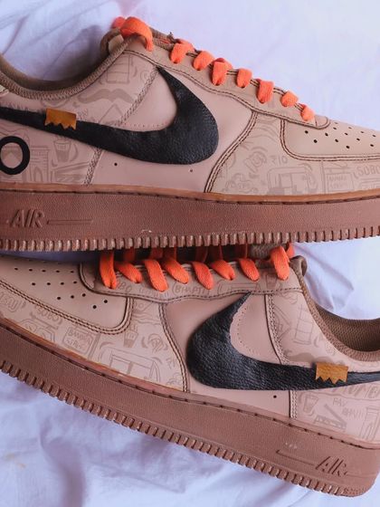 A detailed top-down view of the coffee-dyed Nike AF1s. You can see the intricate Mumbai-themed illustrations covering the shoe, from the local trains to vada pav, all hand-drawn with precision.