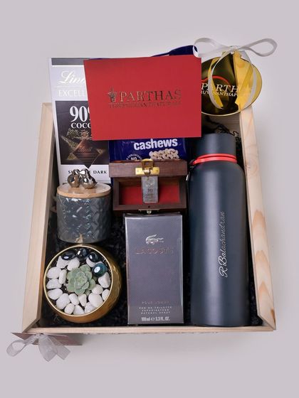 An overhead view of the packed corporate hamper, showing the careful arrangement of high-end items like perfume, chocolate, and a personalized flask.