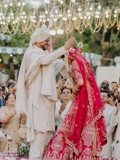 A playful moment during the varmala exchange. These candid shots show the couple's personality and the fun they have together.