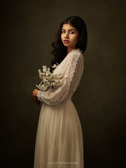 In shadows and light, the soul speaks louder. This portrait, with the subject holding a delicate spray of flowers, is full of quiet grace.