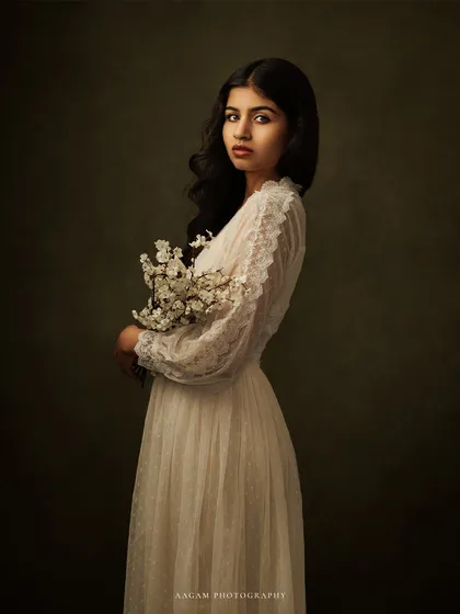In shadows and light, the soul speaks louder. This portrait, with the subject holding a delicate spray of flowers, is full of quiet grace.