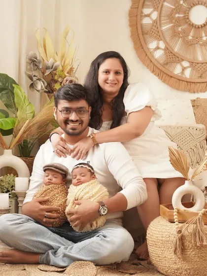 A complete family portrait is the perfect way to announce your new arrivals. Here, we used a warm, bohemian-inspired setup to create a relaxed and joyful photo of the proud parents with their newborn twins.
