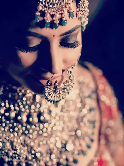 Another beautiful close-up shot highlighting the bride's jewelry and makeup details with dramatic lighting.