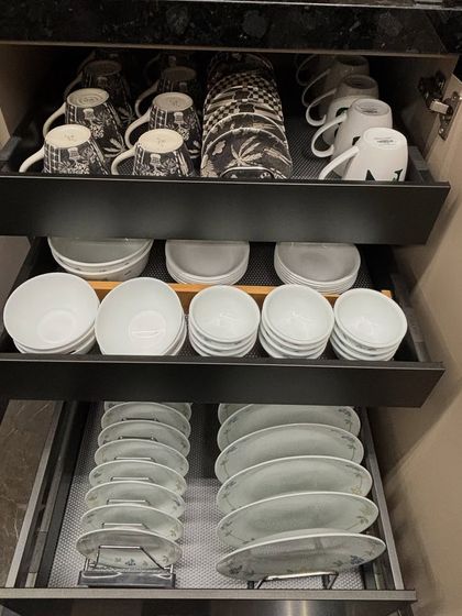 A three-tiered pull-out system for crockery. This makes excellent use of a deep cabinet, allowing you to access items at the back without any hassle.