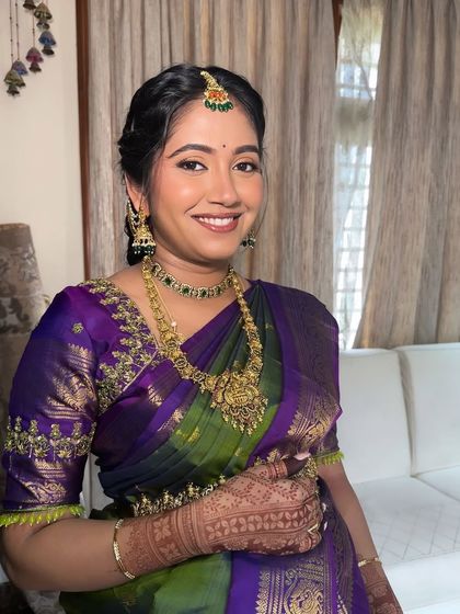 A happy mom-to-be, glowing during her Seemantham ceremony. The makeup is kept elegant and minimal to let her natural beauty shine through.