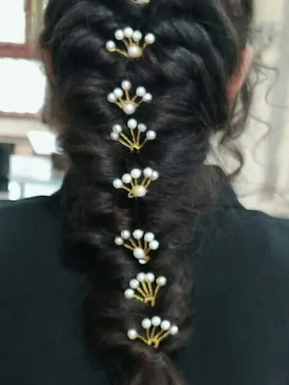 A classic fishtail braid, elegantly styled with pearl hairpins. This demonstrates our students' ability to create neat, clean, and beautifully embellished braids suitable for any festive occasion.