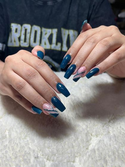 A beautiful set of coffin-shaped extensions in a deep teal color, with accent nails featuring a delicate feather-like design.