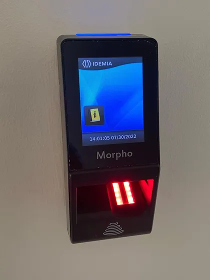 This image captures the Morpho biometric system in its active state, with the fingerprint sensor illuminated. The clear digital display provides user feedback, making the access process quick and intuitive for authorized personnel.