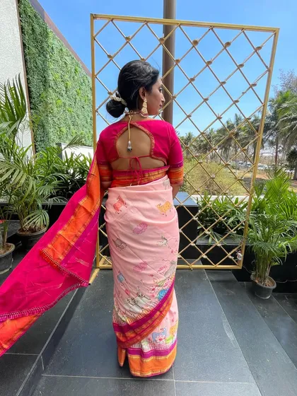 The back view of the client's pink blouse, featuring a simple tie-up detail that complements the lively saree.