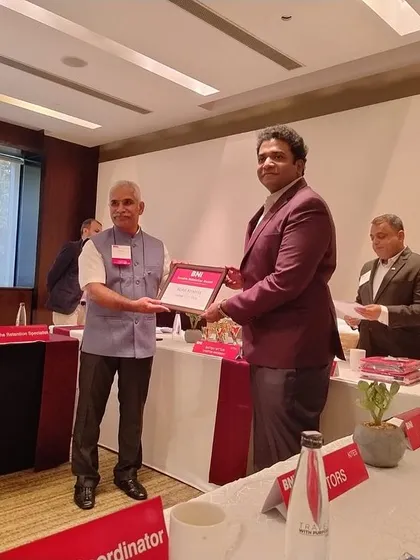 Our COO accepting a recognition on behalf of our Principal Architect from BNI (Business Network International), acknowledging our contributions to the professional community.