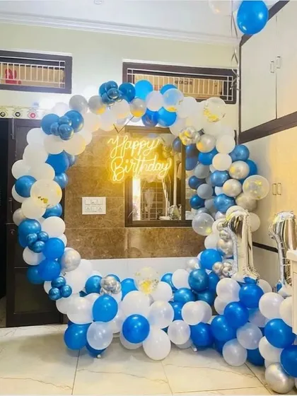 A classic blue and white balloon ring for a first birthday. This home setup is filled with balloons on the floor and accented with silver chrome balloons for extra shine.