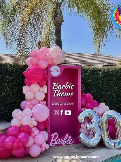 A Barbie theme is perfect for a glamorous celebration. This setup for a 30th birthday featured a life-sized Barbie box for photos, framed by a cascade of pink balloons and large silver foil numbers.