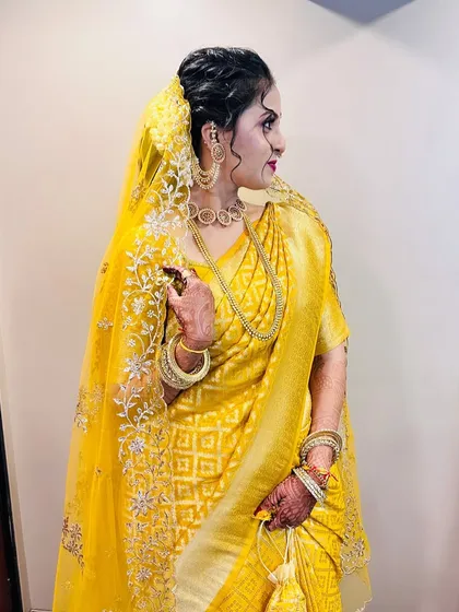 A side profile of the bride, showing her messy bun hairstyle and the beautiful sheer dupatta.