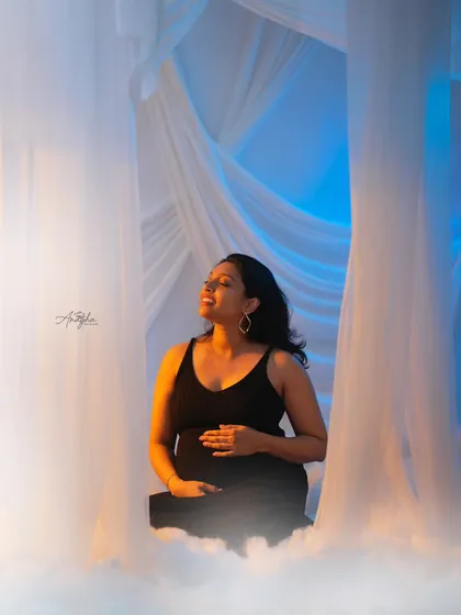 A dreamy and ethereal portrait using flowing white fabrics and a fog machine. The warm and cool lighting creates a magical, heavenly atmosphere.