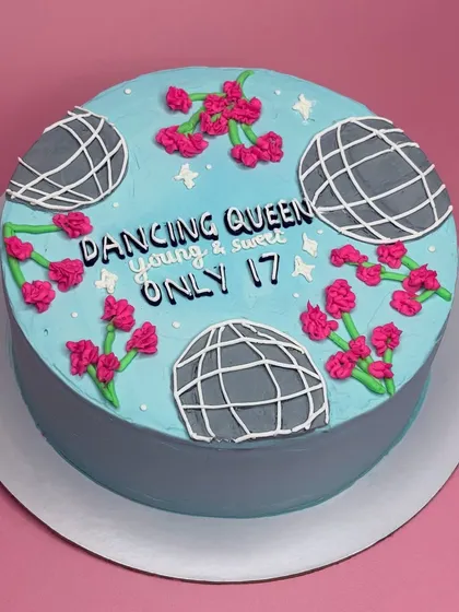 For the "Dancing Queen, young and sweet, only 17". This cake is inspired by the ABBA song and features disco balls and bright pink flowers on a cool blue background.