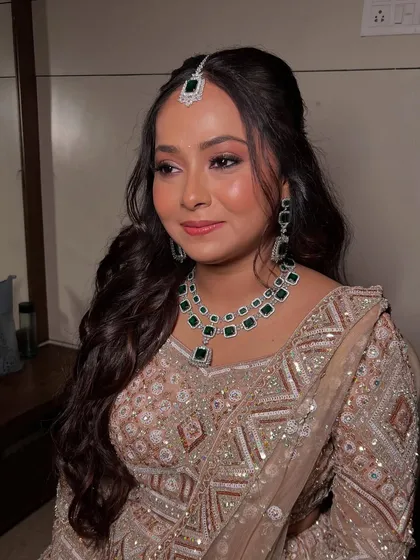 A three-quarter profile of Bhakti, showcasing her soft waves and the beautiful emerald jewellery.