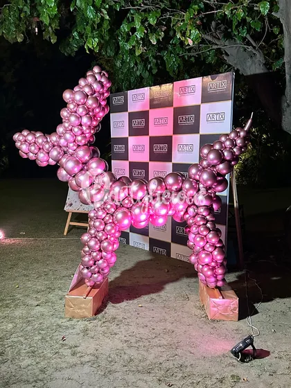 Not your average party decor. This metallic pink balloon dog sculpture, set against a branded backdrop, is a modern and artistic piece that adds a touch of playful sophistication to any event.