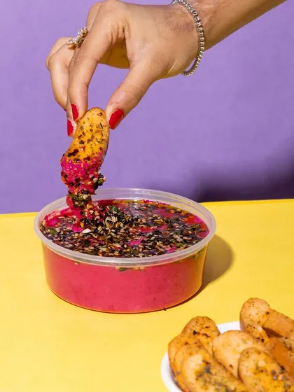 Dipping a crispy crostini into my Sizzling Beetroot Yogurt Dip. It's the perfect combination of creamy, tangy, and crunchy.