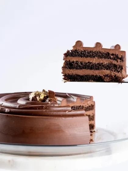A perfect slice of our classic Belgian Chocolate cake being lifted, showing its rich, moist layers. This is a timeless choice for any chocolate lover.