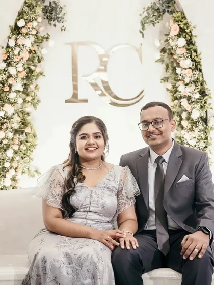 A classic and elegant engagement photo backdrop. The couple's monogram is framed by two beautiful arches of pastel roses, creating a timeless and romantic setting.