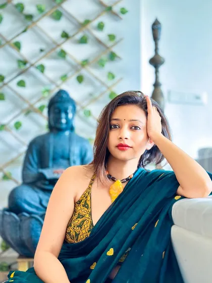 A close-up portrait in the green heart saree. The halter neck blouse adds a modern, sultry touch to the traditional fabric.