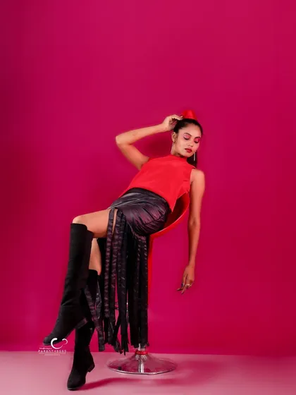 A high-fashion, off-balance pose on a stool that is both artistic and daring. It breaks the rules of conventional portraiture.