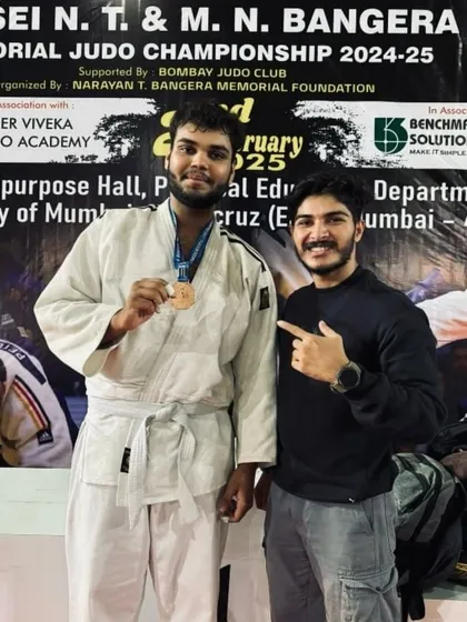 A coach congratulates one of our Judokas for his performance and medal win at the Judo championship. This one on one encouragement is a key part of our supportive, family like environment.