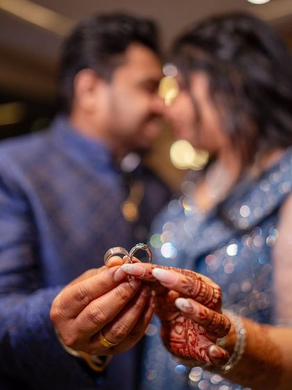 A classic engagement ring shot, with the couple holding their rings together in the foreground.